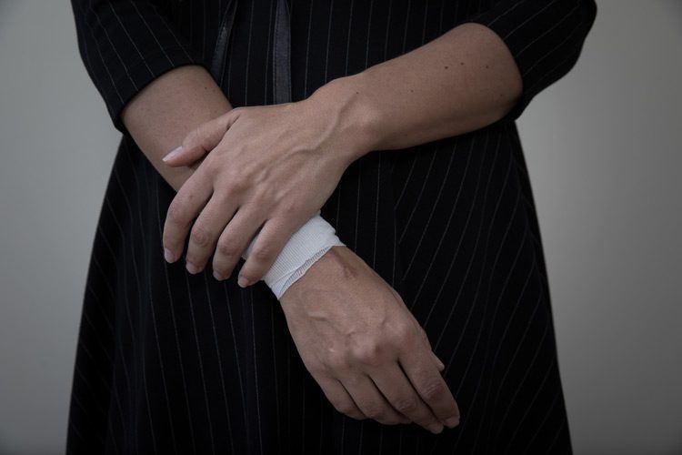 cropped shot of a woman with a bandage on her wrist - self-harm awareness